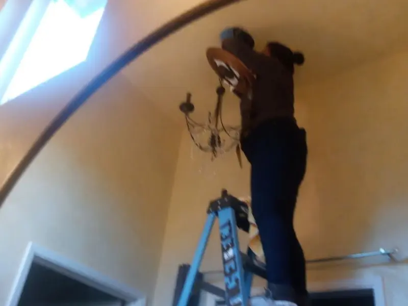 Electrician installing a chandelier in a Palo Cedro residence